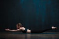 Young woman practicing yoga against dark wall Royalty Free Stock Photo