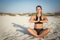 Young woman practicing yoga on the beach. Royalty Free Stock Photo