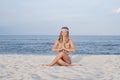 Young woman practicing yoga on the beach in Gomukasana pose Royalty Free Stock Photo