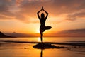 A young woman practicing yoga on the beach at sunset Royalty Free Stock Photo