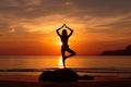 A young woman practicing yoga on the beach at sunset Royalty Free Stock Photo