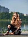 Young woman practicing yoga at city lake Royalty Free Stock Photo