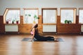 Young woman practicing yoga, doing Cobra exercise, Bhujangasana pose, working out, wearing sportswear, black pants and Royalty Free Stock Photo