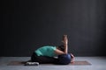 Woman practicing yoga, Seated forward bend pose, using block and bolster