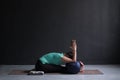 Woman practicing yoga, Seated forward bend pose, using block and bolster Royalty Free Stock Photo