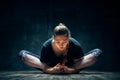 Young woman practicing yoga doing reclined goddess pose asana in dark room Royalty Free Stock Photo