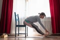 Young woman practicing yoga, doing seated forward bend pose, paschimothanasana