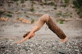 Young woman practicing yoga in downward facing dog pose on beach Royalty Free Stock Photo