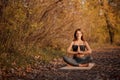 Young woman practicing yoga exercise in autumn park with yellow leaves. Sports and recreation lifestyle Royalty Free Stock Photo