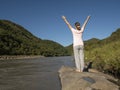 Young woman is practicing yoga in hand up pose at mountain lake Royalty Free Stock Photo