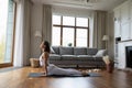 Young woman practicing yoga at home, doing Upward Facing Dog