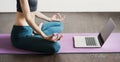 Young woman practicing yoga at home. Online video training. Girl doing exercises and meditate Royalty Free Stock Photo