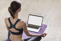 Young woman practicing yoga at home. Online video training. Girl doing exercises and meditate. Royalty Free Stock Photo