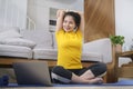 Young woman practicing yoga at home and watching online workout lesson on laptop. Healthy lifestyle concept