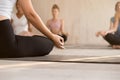 Young woman practicing yoga, instructor and group doing Sukhasan