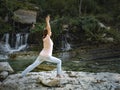 Young woman is practicing yoga in lotus pose at mountain lake Royalty Free Stock Photo