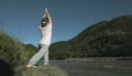 Young woman is practicing yoga in lotus pose at mountain lake Royalty Free Stock Photo