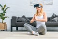 Young woman practicing yoga in lotus position and using virtual reality