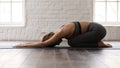 Young woman practicing yoga, lying in Child pose, Balasana exercise