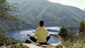 Young woman practicing yoga, meditating on nature. Girl relaxing on background mountain lake. Mindfulness, mental health Royalty Free Stock Photo