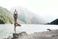 Young woman is practicing yoga at mountain lake Royalty Free Stock Photo