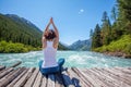 Young woman is practicing yoga at mountain river Royalty Free Stock Photo