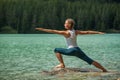 Young woman is practicing yoga at mountain river Royalty Free Stock Photo