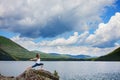 Young woman is practicing yoga at mountain river Royalty Free Stock Photo