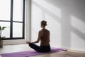 Young woman practicing yoga near floor window in yoga studio, Young girl meditating at home Royalty Free Stock Photo