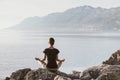 Young woman practicing yoga near the sea. Harmony and meditation concept.