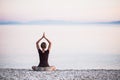 Young woman practicing yoga near the sea. Harmony and meditation concept. Royalty Free Stock Photo