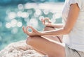 Young woman practicing yoga near the sea in summer. Harmony and meditation concept.