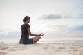 Young woman practicing yoga outdoors. Girl meditating with sunset sea view at background Royalty Free Stock Photo
