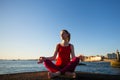 A young woman practicing yoga on the pier near the sea. Royalty Free Stock Photo