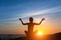 Young woman practicing yoga on the sea beach during amazing sunset. Royalty Free Stock Photo