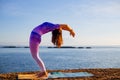 Young woman practicing yoga, standing in Hasta Uttanasana pose, deflection back. Self care concept. Bali, Indonesia