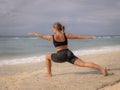 Young woman practicing yoga. Standing in Virabhadrasana II pose, Warrior II Pose. Work out. Healthy lifestyle. Strong body. Ocean Royalty Free Stock Photo