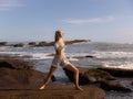 Young woman practicing yoga. Standing in Virabhadrasana II pose, Warrior II Pose. Work out. Healthy lifestyle. Strong body. Ocean Royalty Free Stock Photo