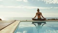 Young woman practicing yoga by a swimming pool with ocean in the background. Royalty Free Stock Photo