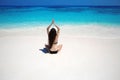 Young woman practicing yoga on the tropical beach with blue water and white sand. Lotus pose. Lifestyle. Relax. Meditation. Royalty Free Stock Photo