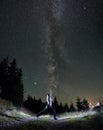 Young woman practicing yoga under night starry sky. Royalty Free Stock Photo