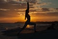 Young woman practicing yoga warrior and hero pose at sunset, sunrise . Zen wellness and wellbeing concept. Royalty Free Stock Photo