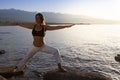 Young woman is practicing yoga in lotus pose at mountain lake Royalty Free Stock Photo