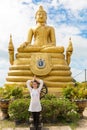 Young woman praying and meditating Gold Buddha near, Thailand, Phuket