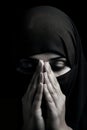 young woman praying, religious, thoughtful, head covered, arabic authenticity, dark background, soft light