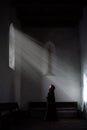 Young woman praying in Romanian ancient Catholic church, historical Villages with fortified churches in Transylvania