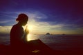Young woman praying sunset over the Ocean Concept Royalty Free Stock Photo