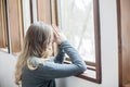 Young woman praying by window Royalty Free Stock Photo