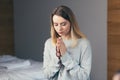 Young woman prays to God, folded her arms on her chest uses a rosary and a crucifix