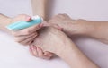 The young woman prepared to apply the cream on the hands of an elderly woman